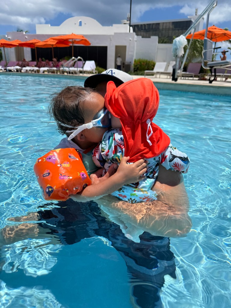 Brothers playing together at the beach with sun hats