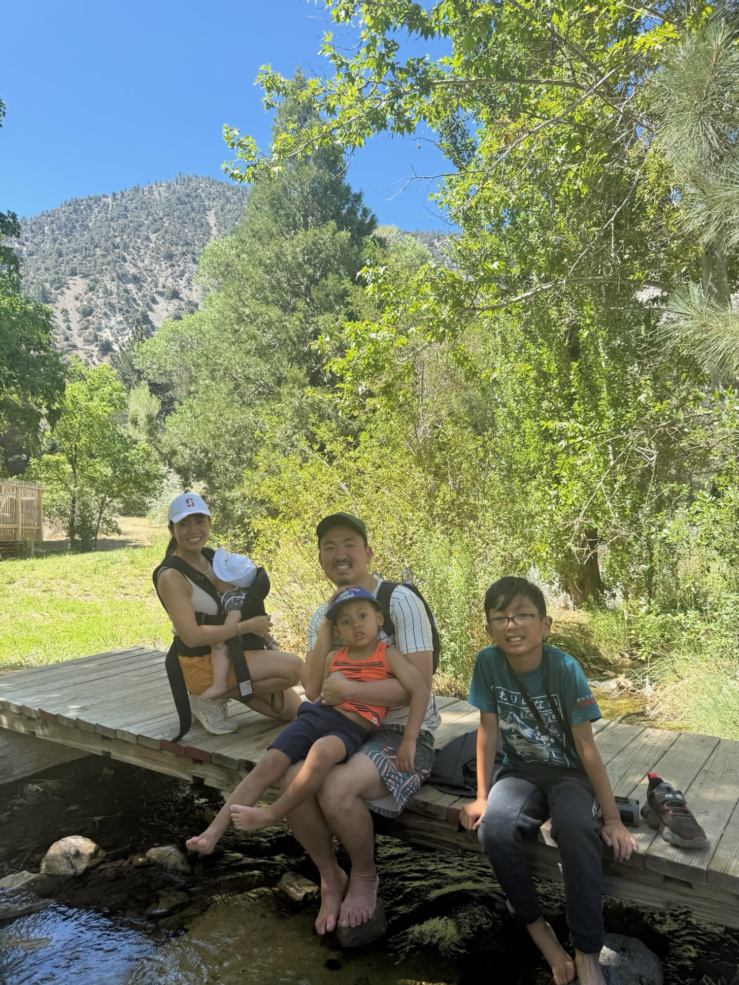 Family hanging out by the stream after a hike